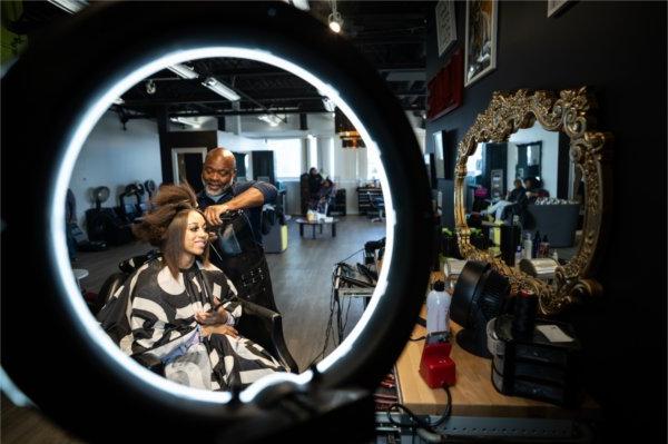 沙龙老板杰里·赖特正在给顾客做头发，头发被投射在镜子里